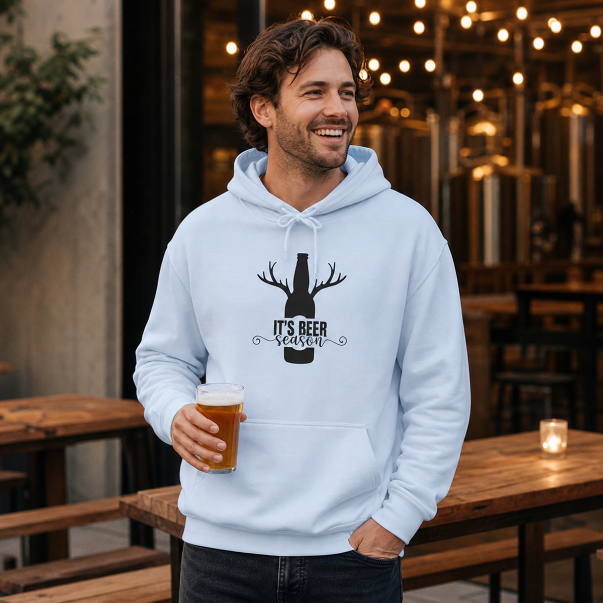 Young man wearing It's Beer Season antler hoodie at a craft brewery patio