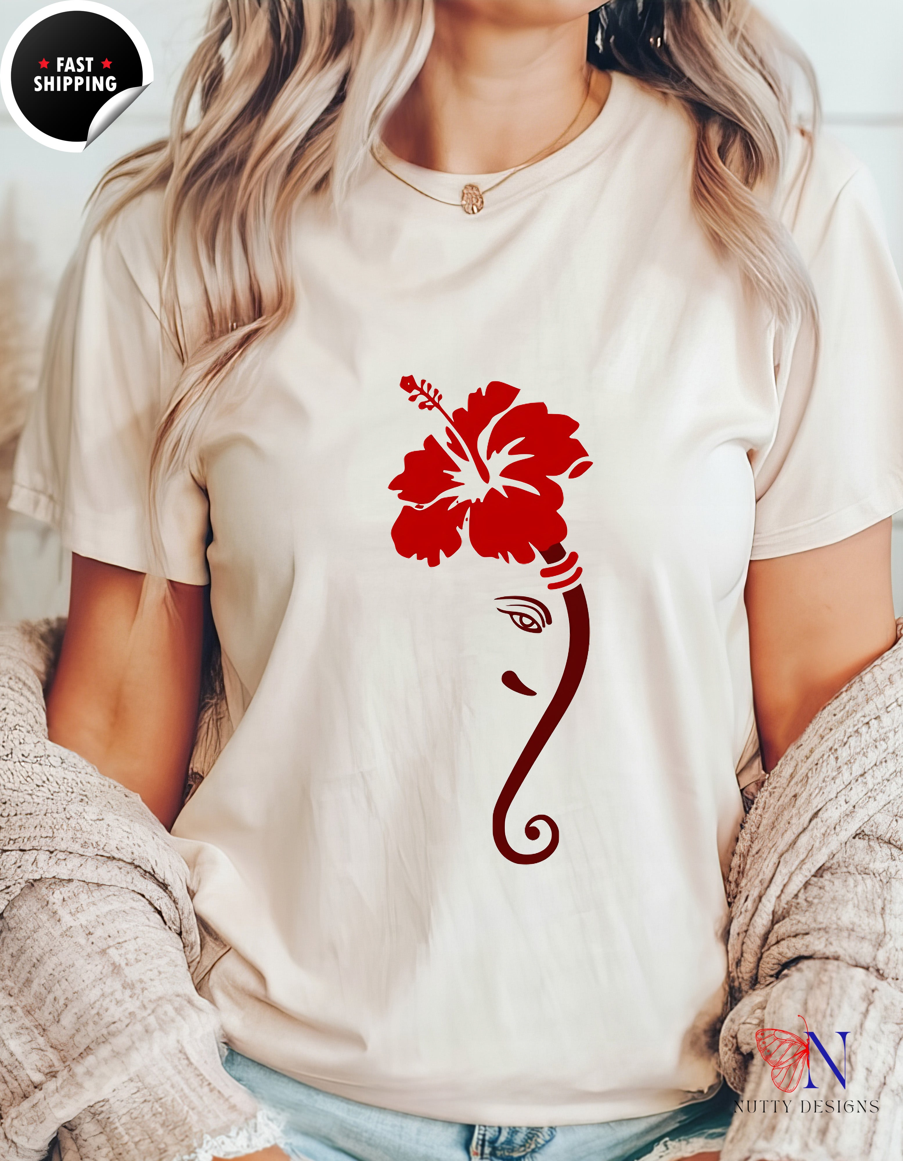 a woman wearing a white shirt with a red flower on it