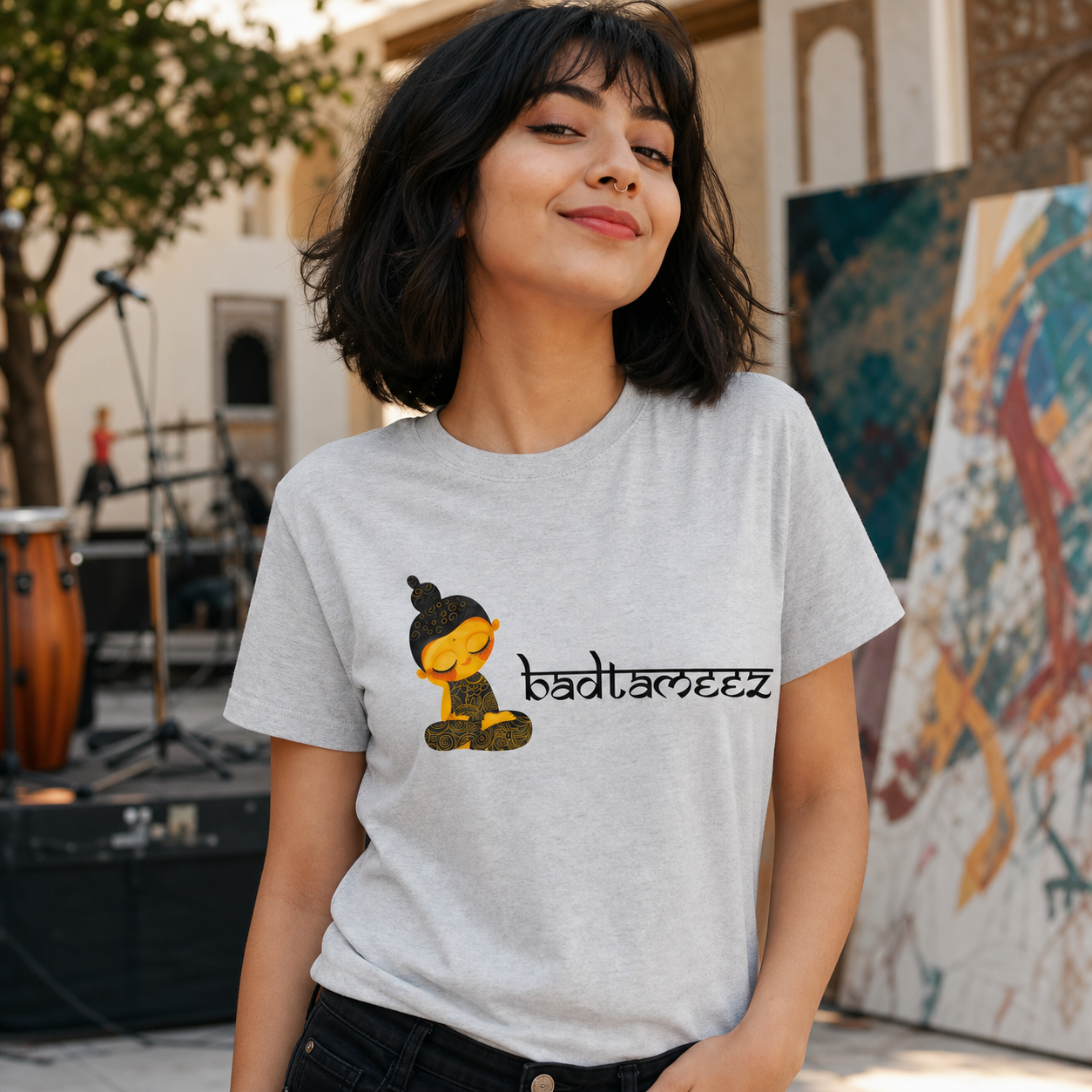 Young North Indian woman wearing gray Badtameez graphic T-shirt at an arts courtyard