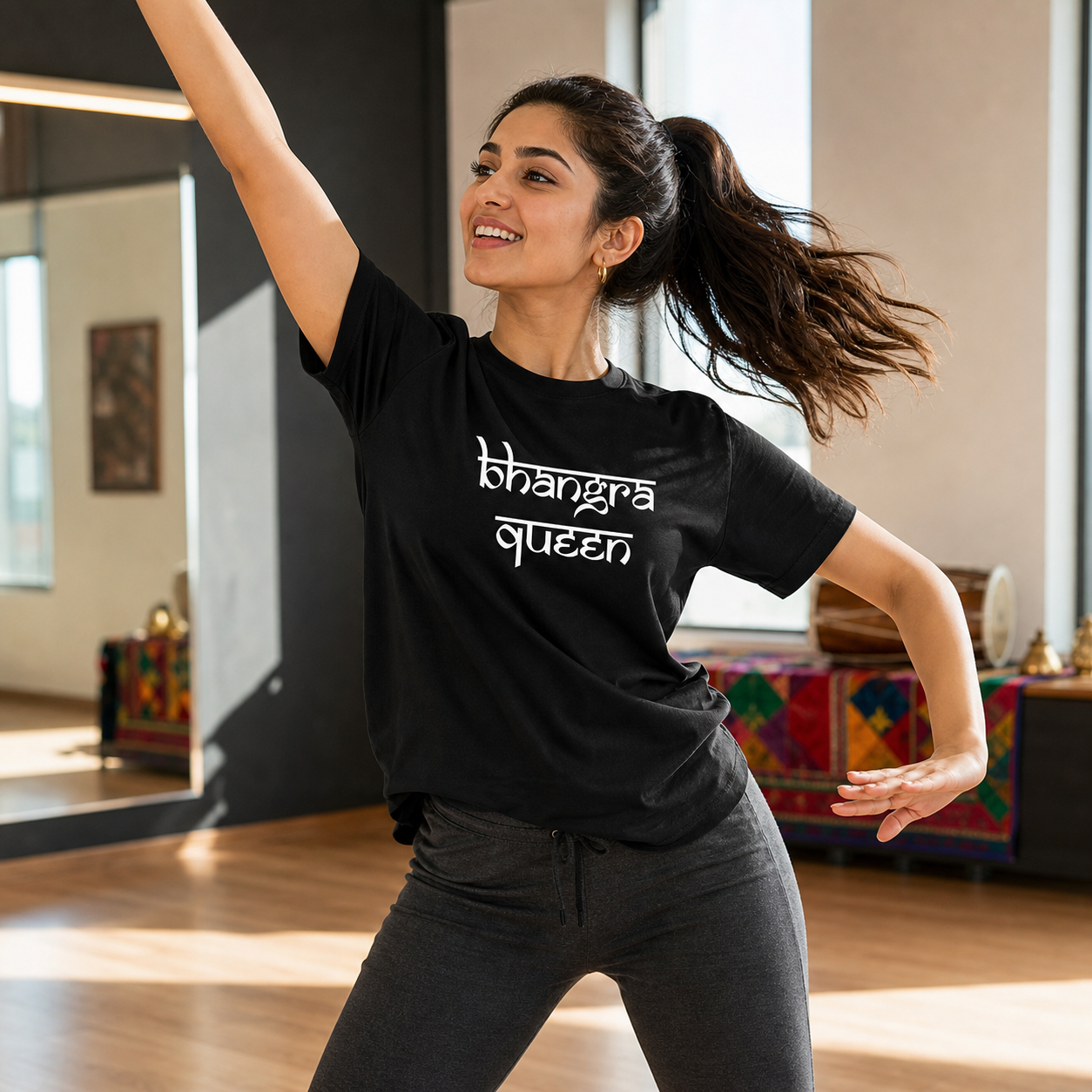 Young Punjabi woman dancing Bhangra in a black Bhangra Queen T-shirt