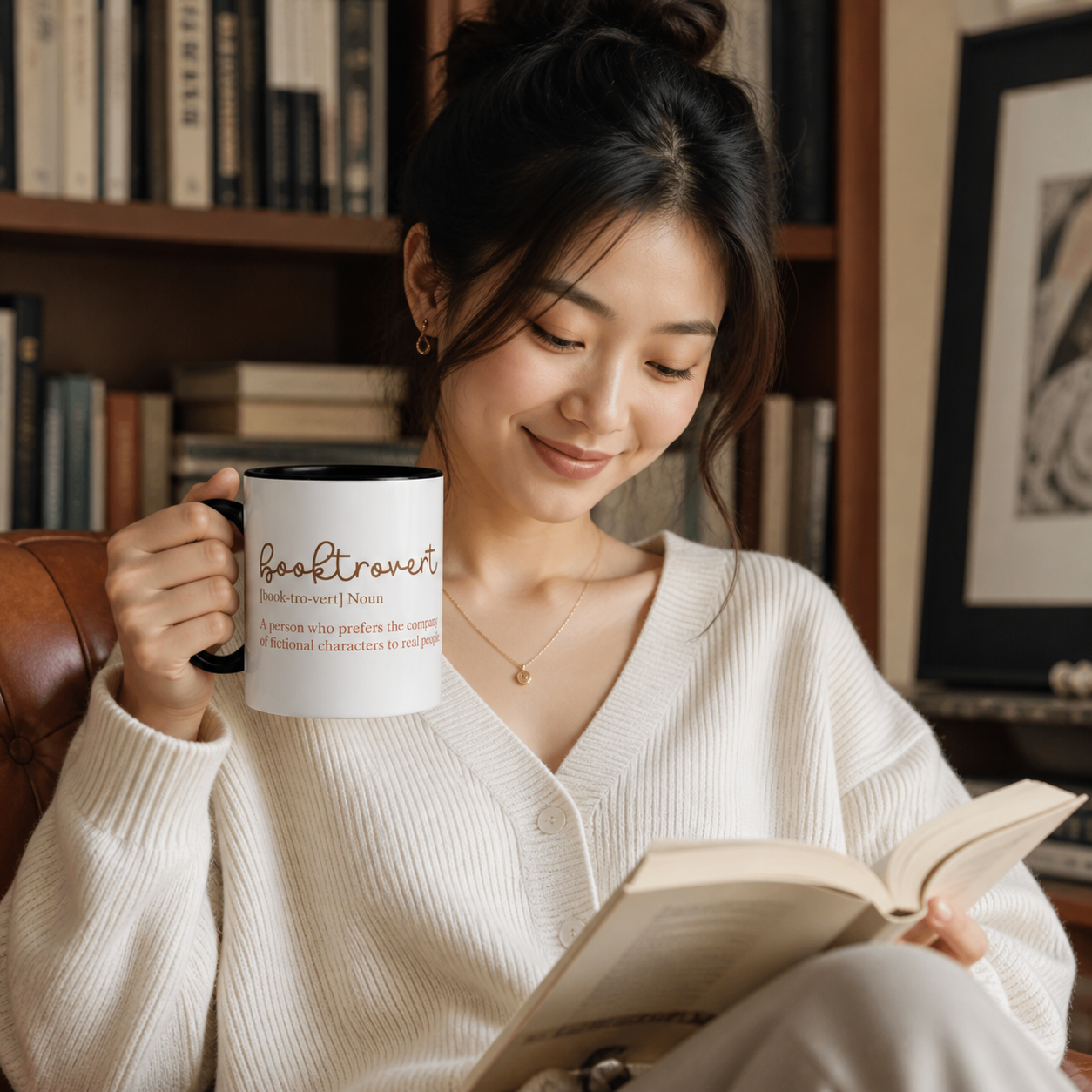Young reader holding black-accent Booktrovert definition mug