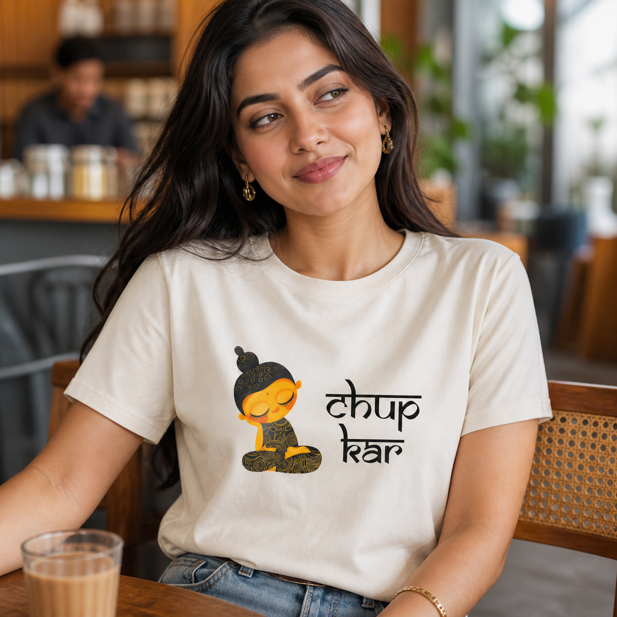 Young North Indian woman wearing ivory Chup Kar graphic T-shirt at a chai café