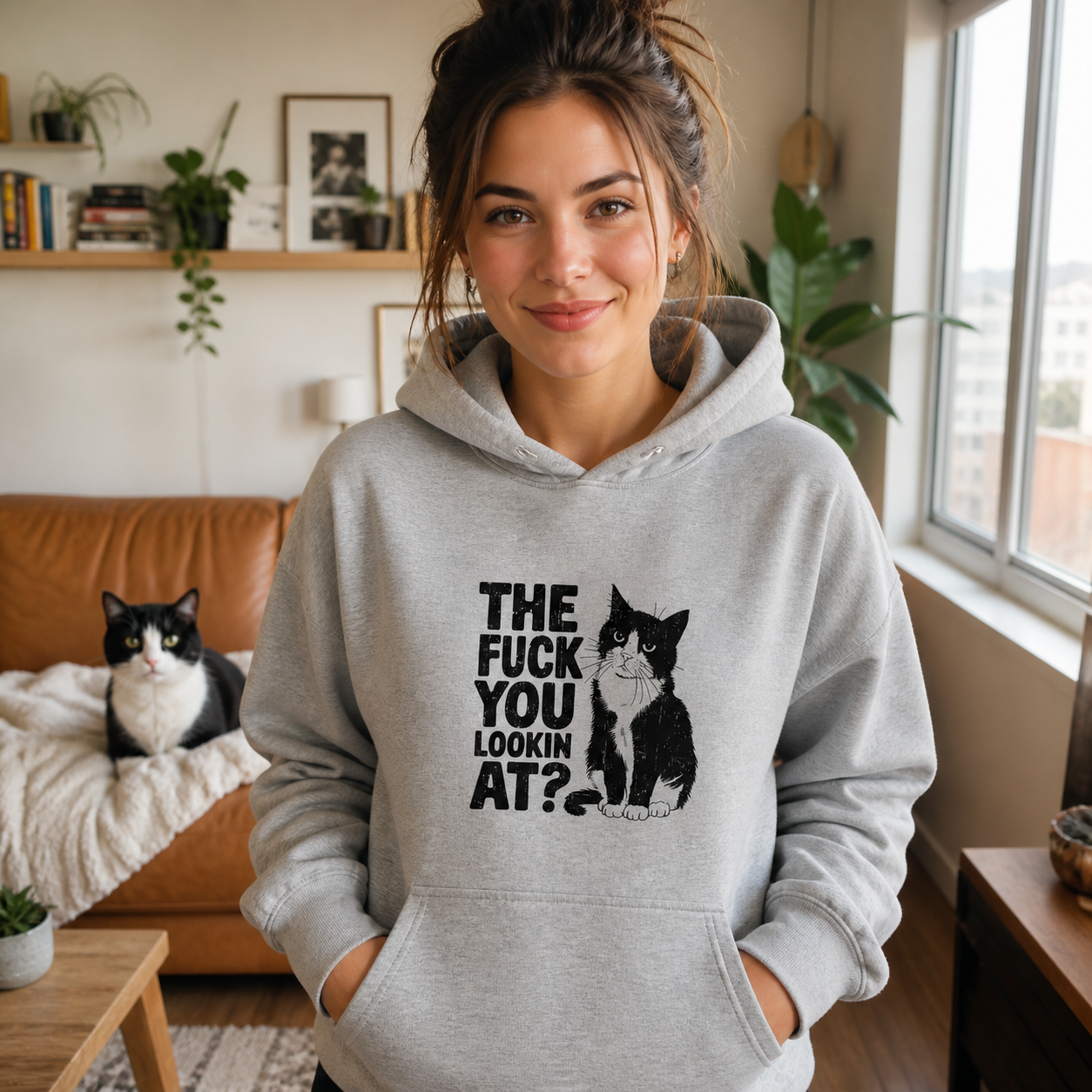 Woman wearing gray funny cat graphic hoodie in a modern apartment