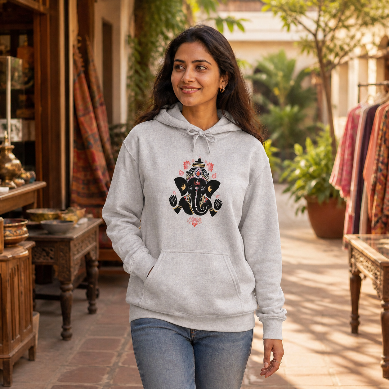 Young Indian woman wearing a Sport Grey Ganesha graphic hoodie at an artisan market