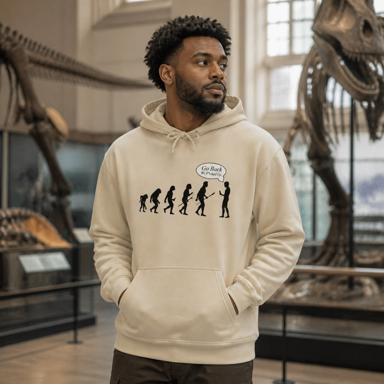 Young man wearing Go Back satirical evolution hoodie in a natural history museum
