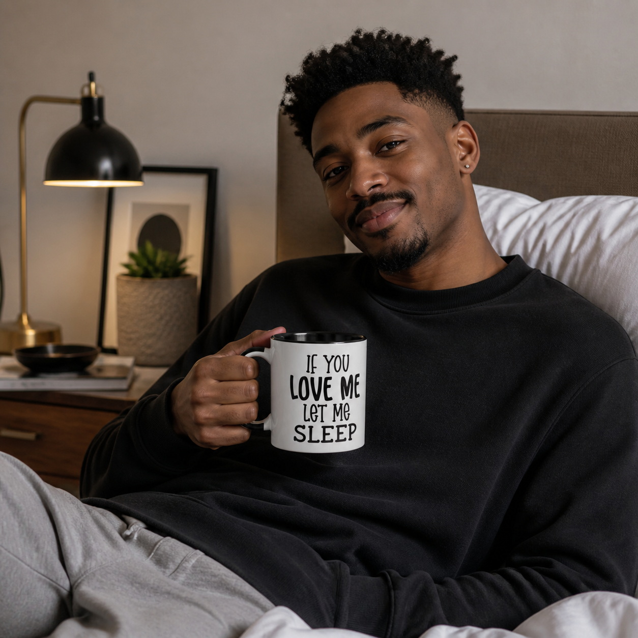 Young man holding black-accent If You Love Me Let Me Sleep mug