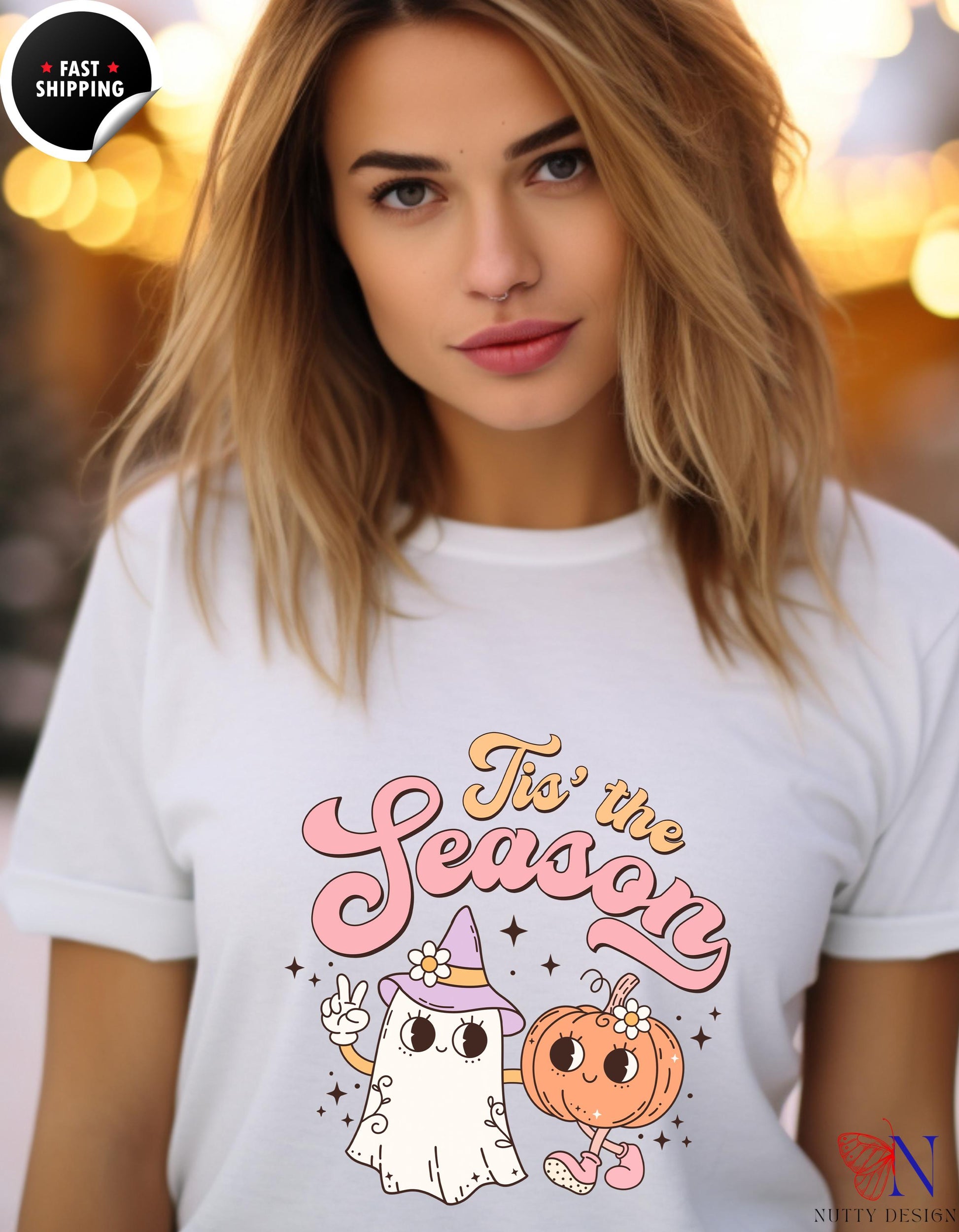 a woman wearing a white tshirt with a ghost and a pumpkin on it