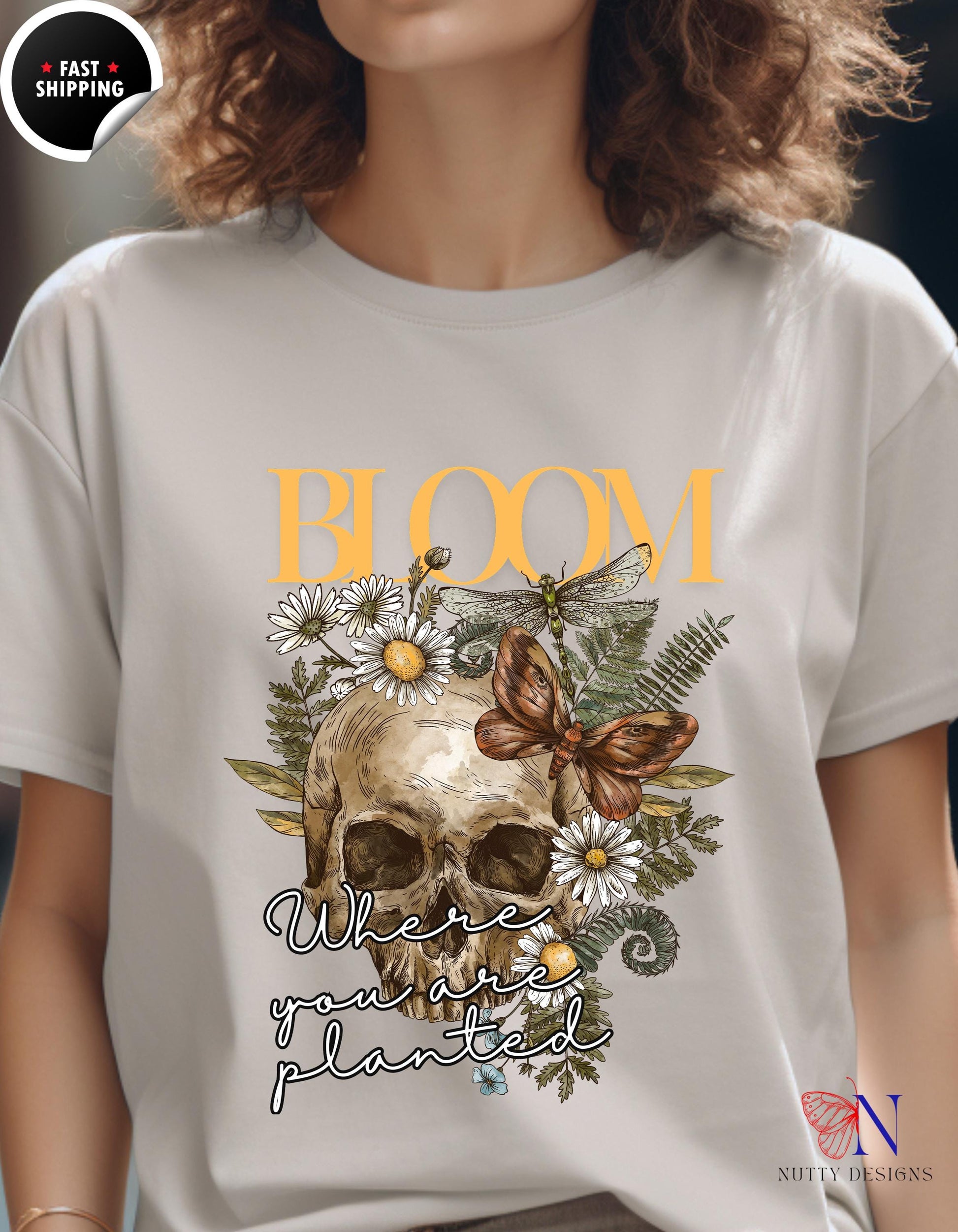 a woman wearing a t - shirt with a skull and flowers on it