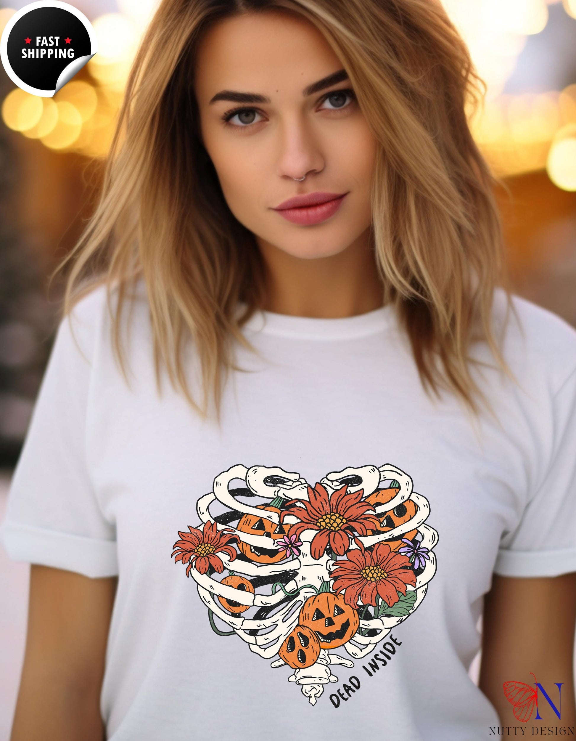 a woman wearing a white t - shirt with a skull and flowers on it