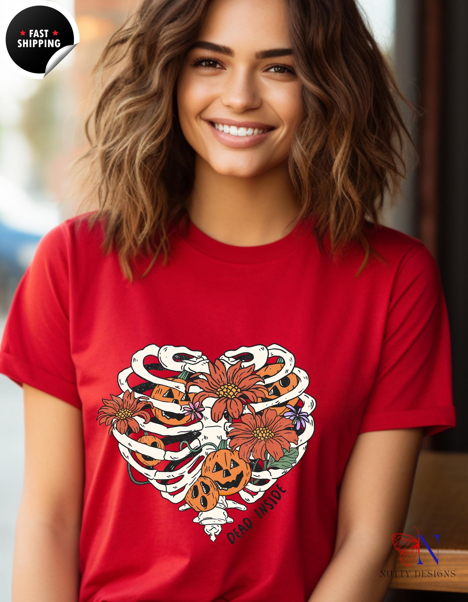 a woman wearing a red t - shirt with a skeleton and flowers on it