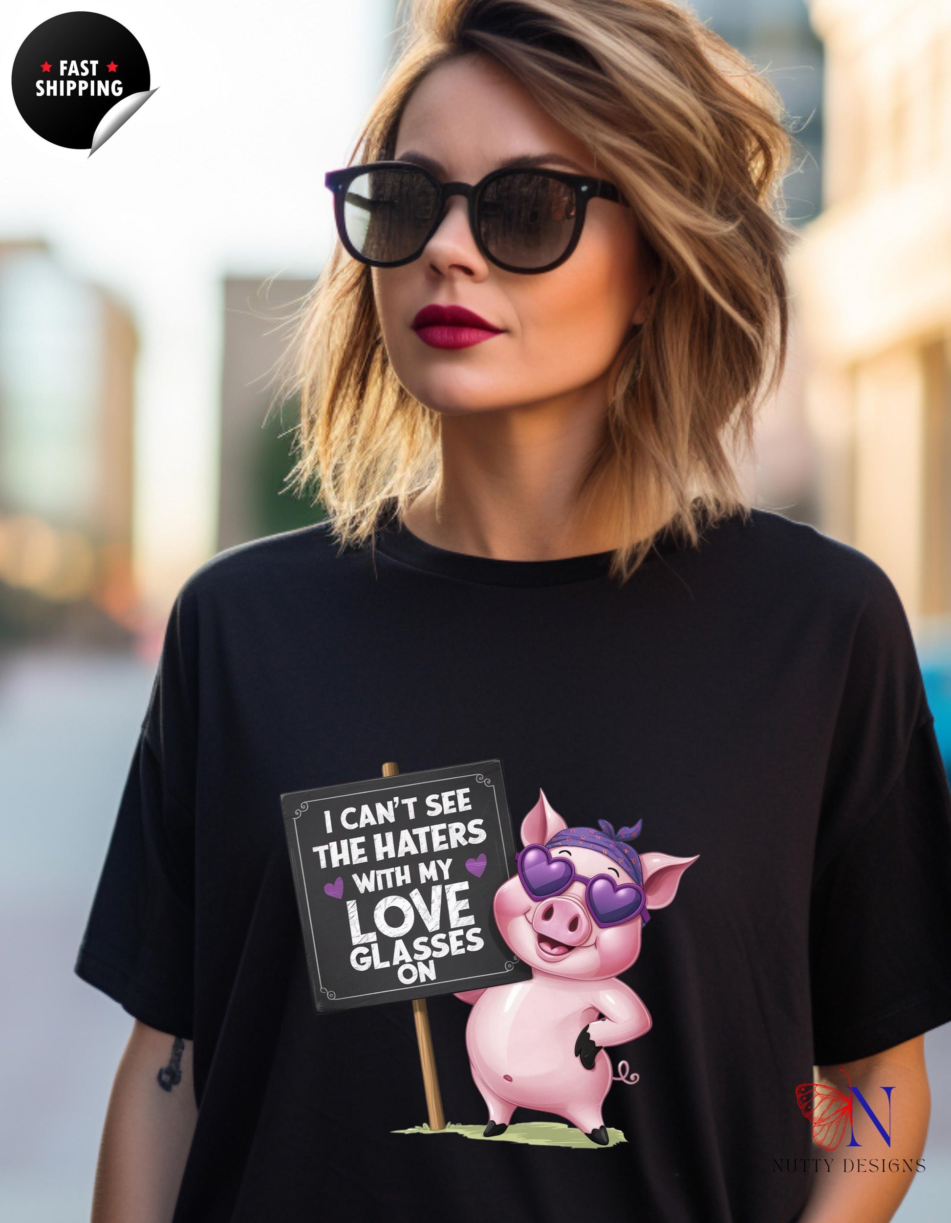 a woman wearing a black shirt with a pink pig on it