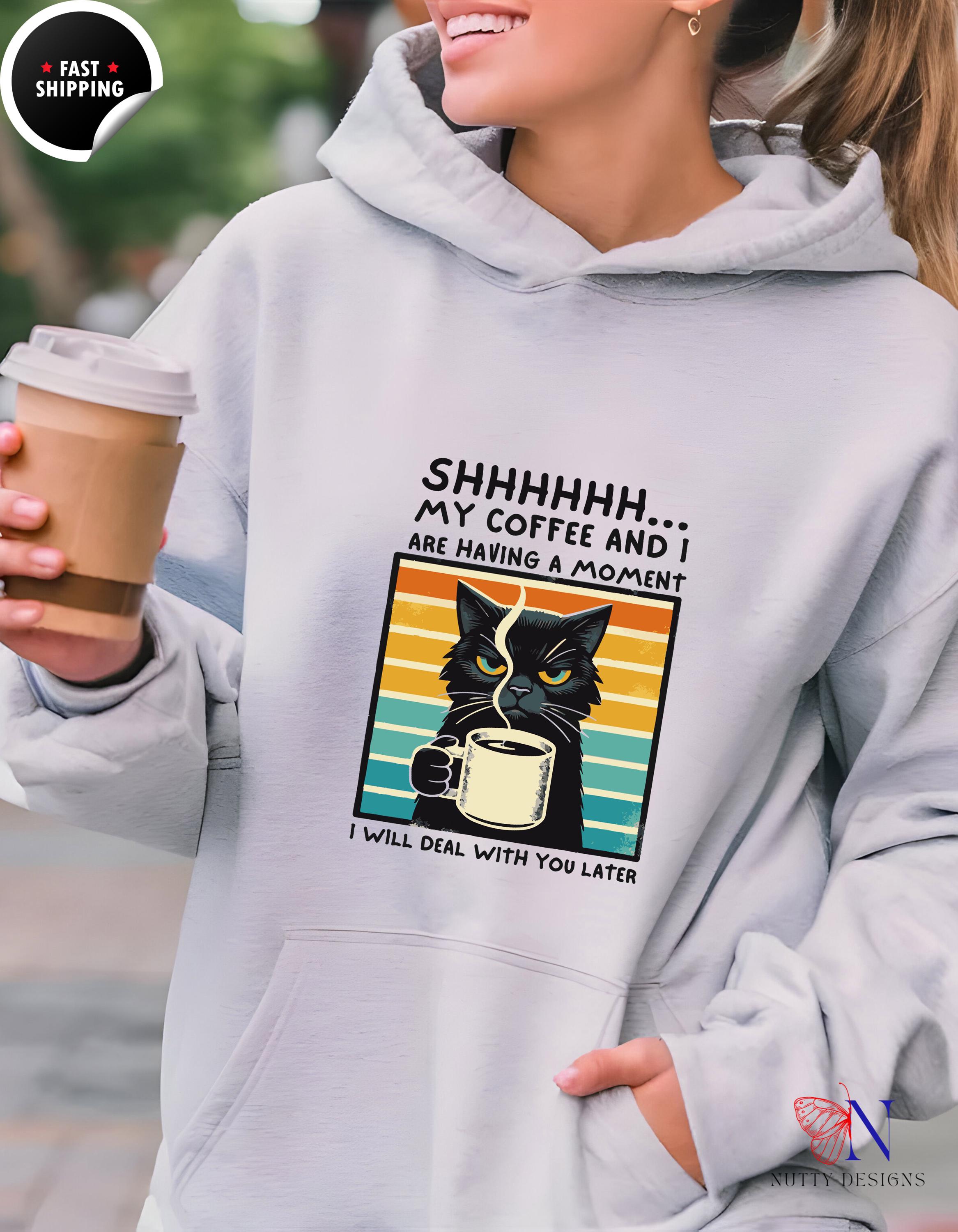 Unisex heavy blend hoodie featuring a cat design and coffee quote, perfect for cozy relaxation.