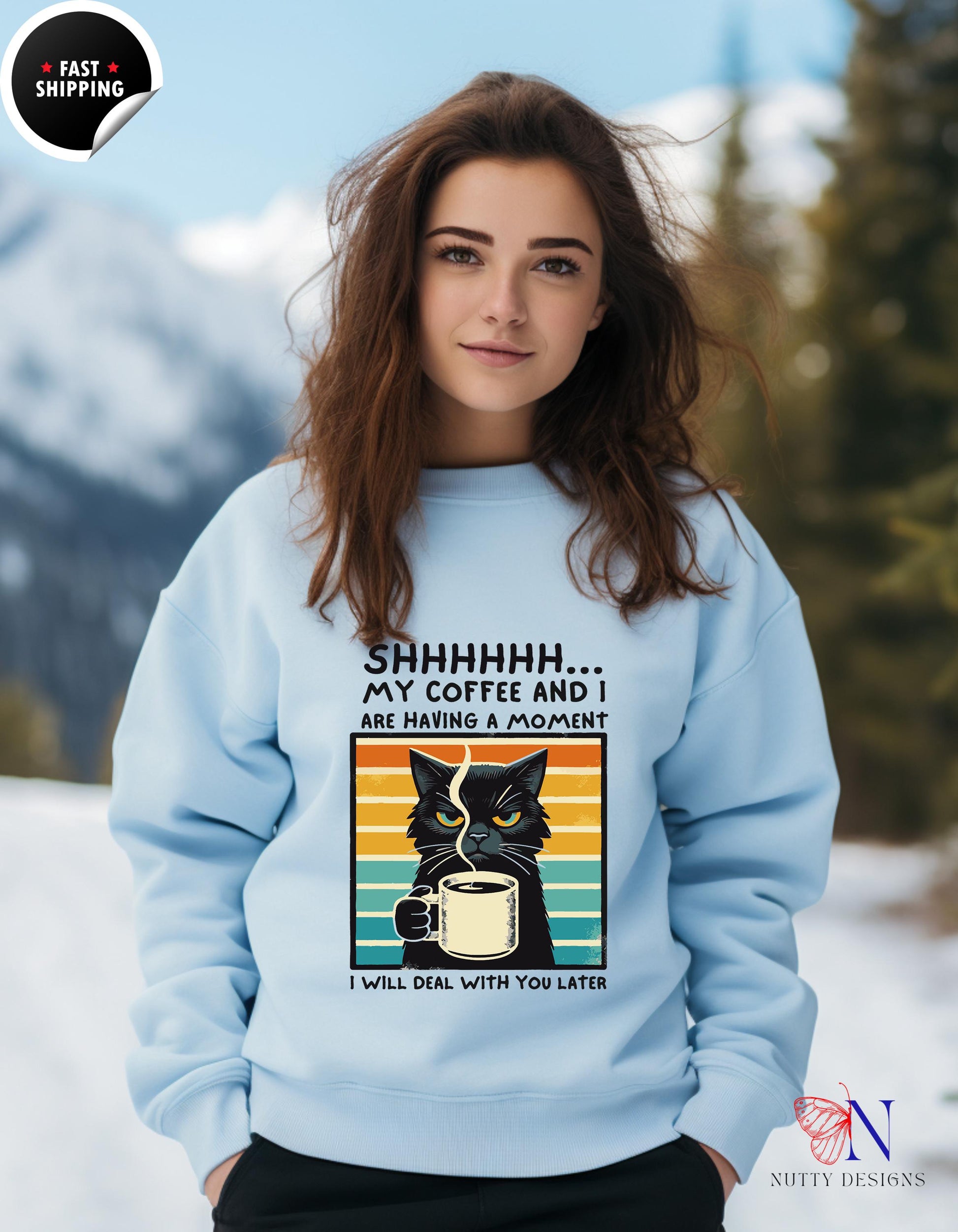 a woman wearing a blue sweatshirt with a black cat on it