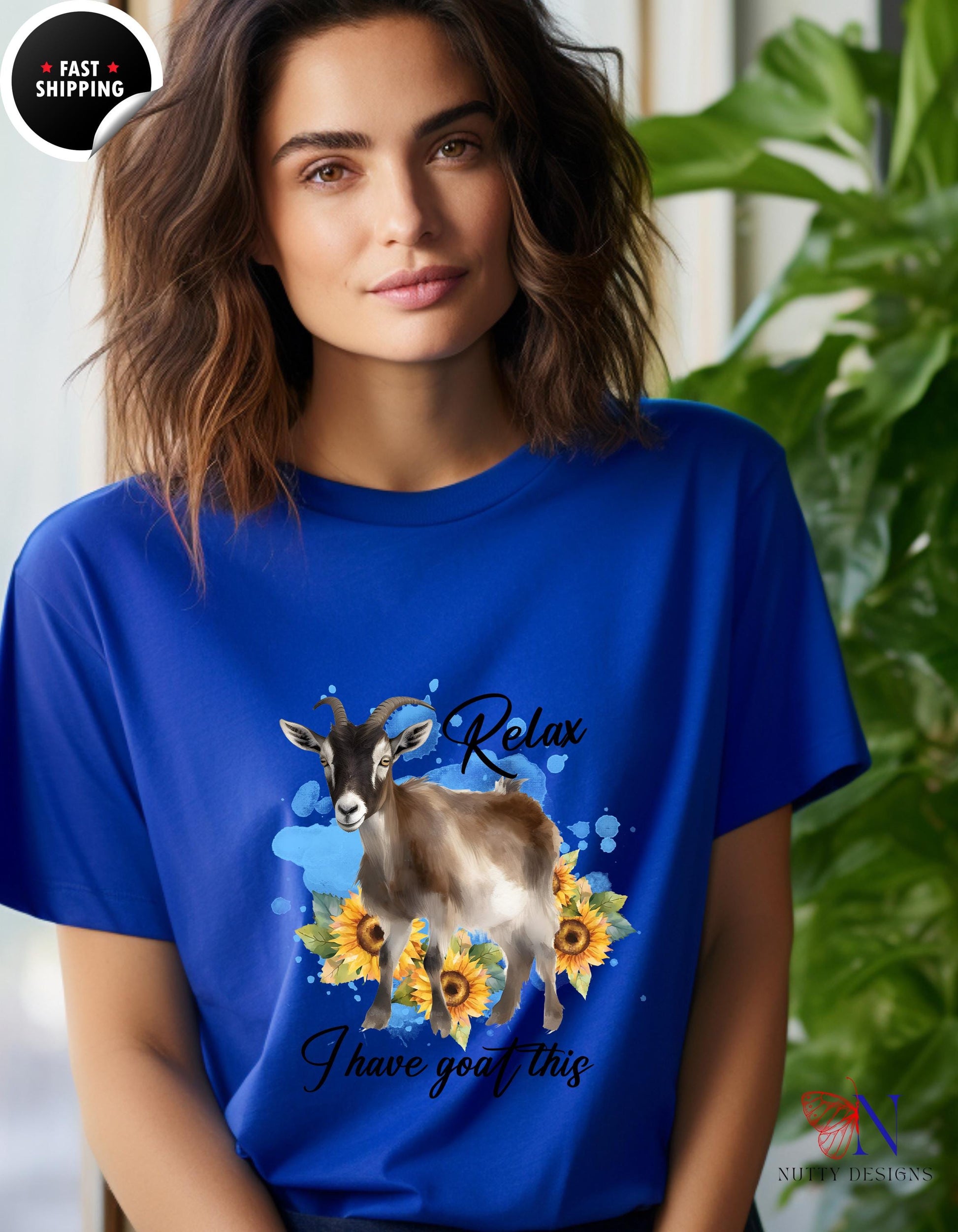 a woman wearing a blue t - shirt with a picture of a goat on it