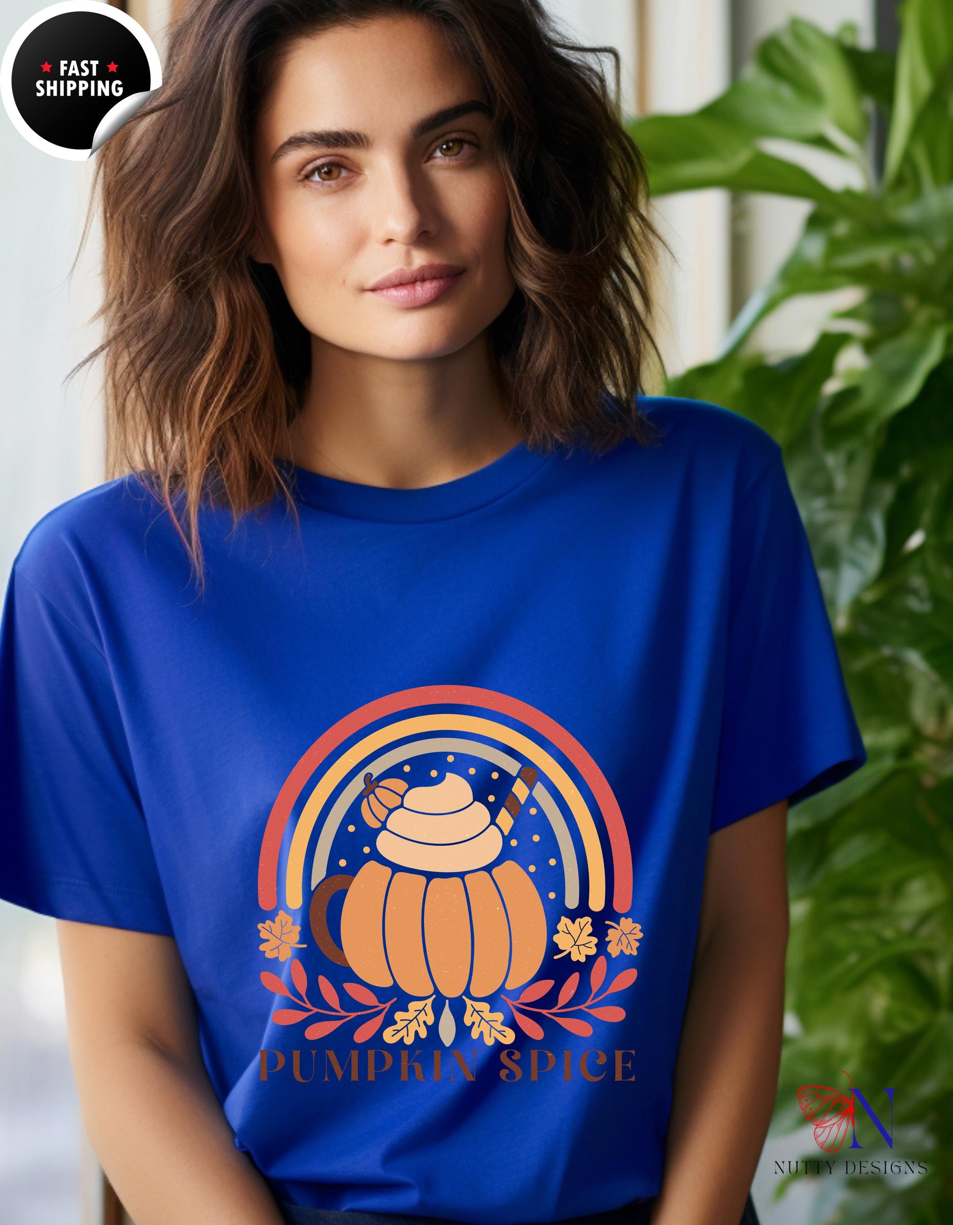 a woman wearing a blue t - shirt with a pumpkin on it