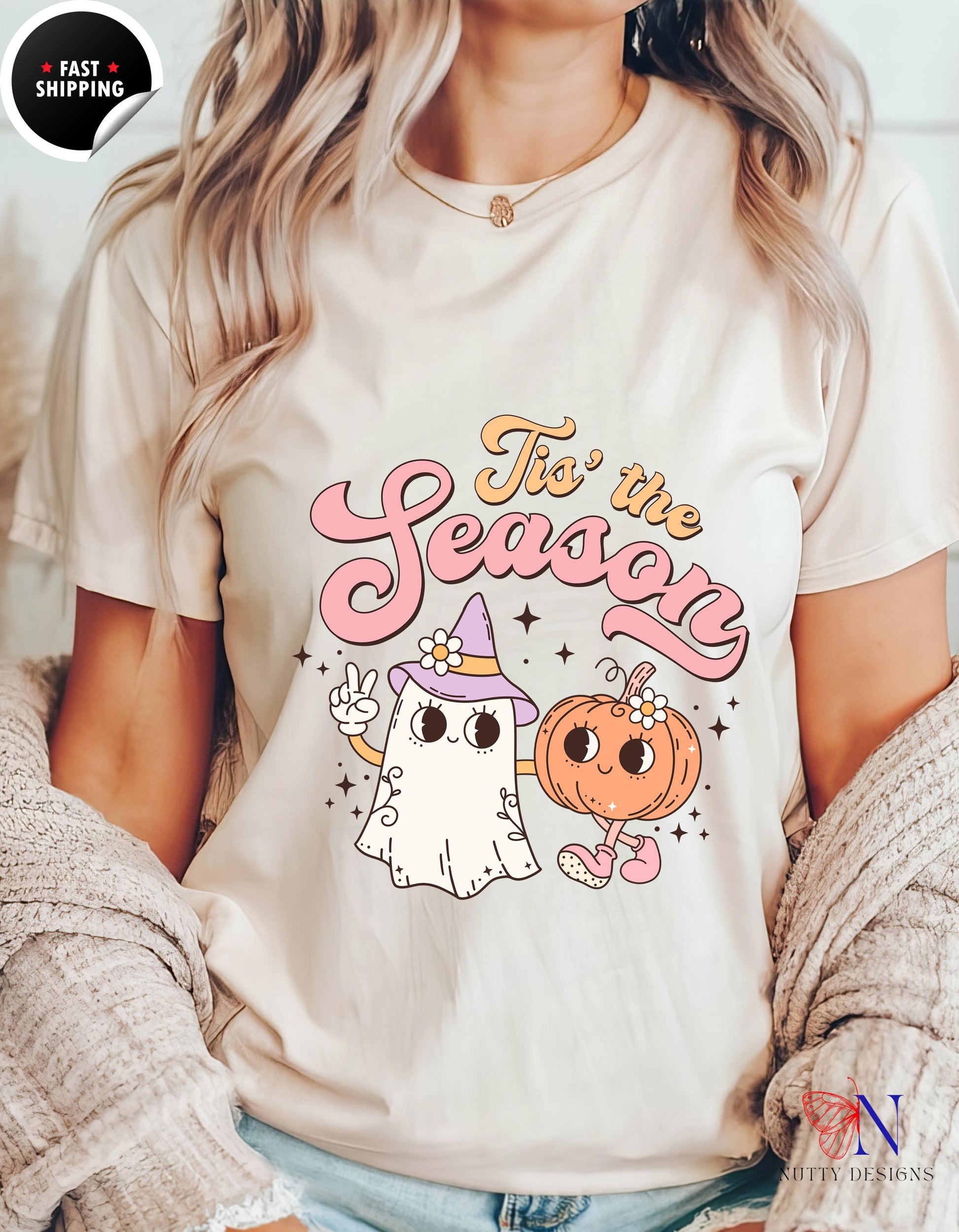 a woman wearing a t - shirt with a ghost and a pumpkin on it