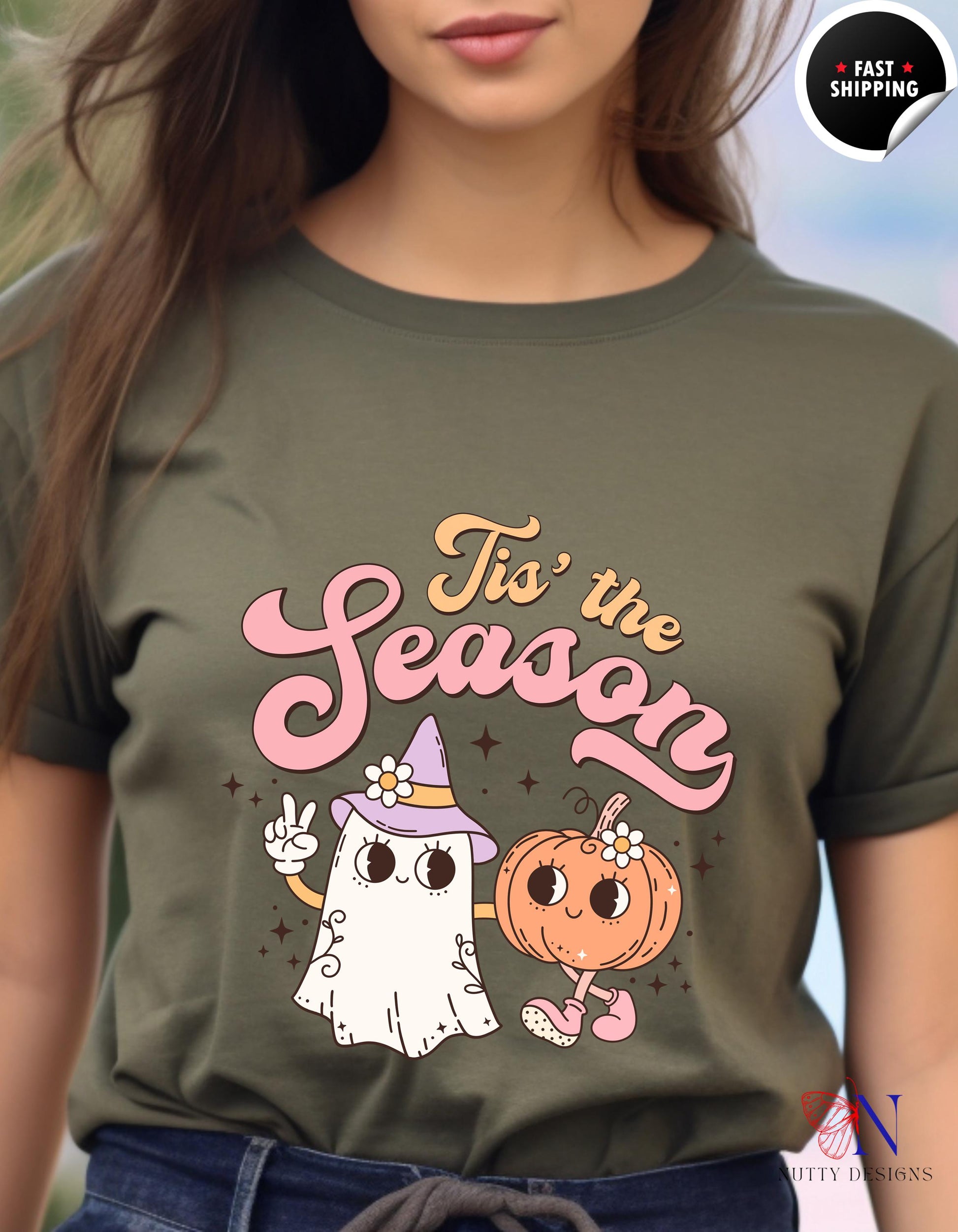 a woman wearing a t - shirt with a ghost and a pumpkin on it