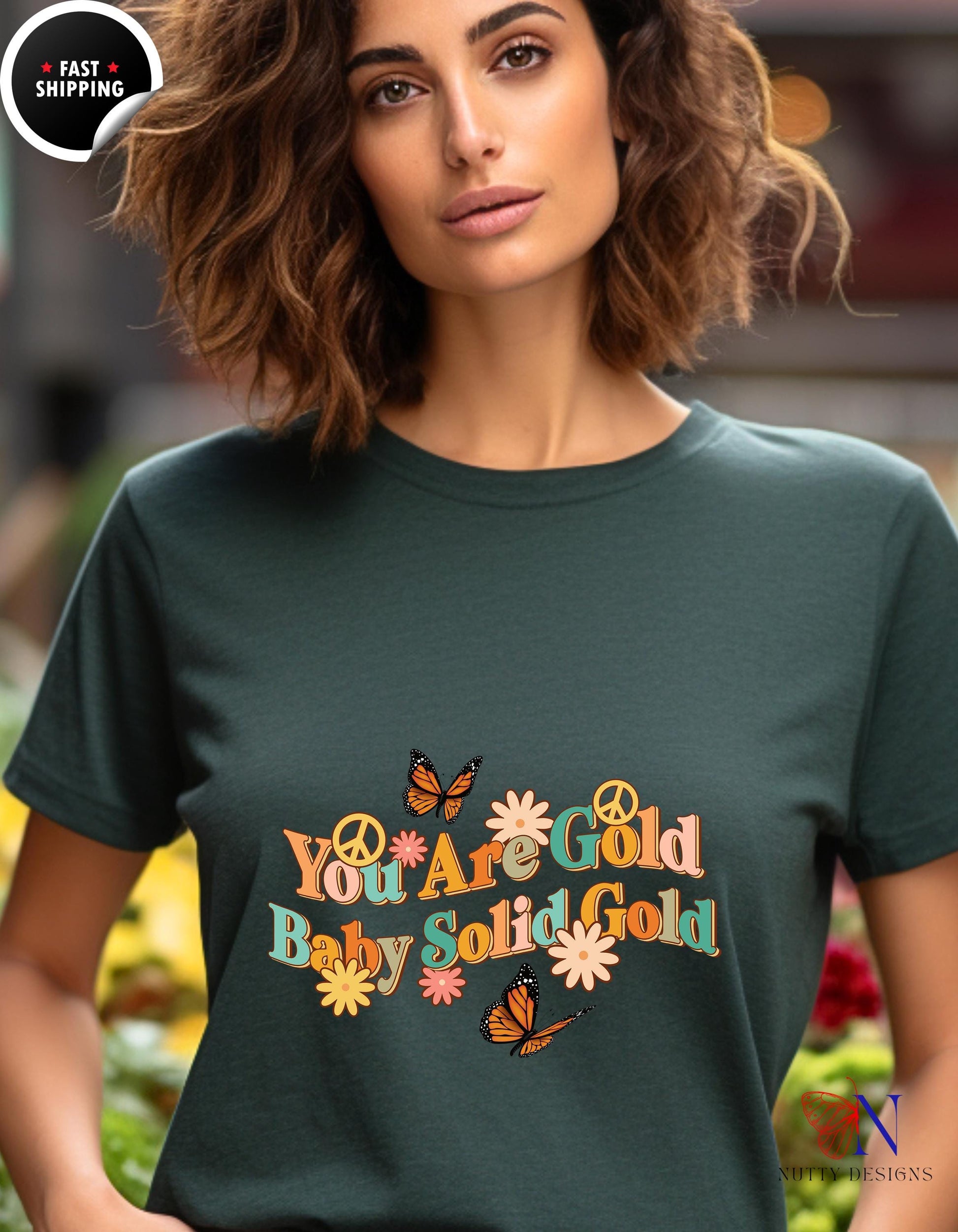 a woman wearing a t - shirt that says you are gold, baby, gold