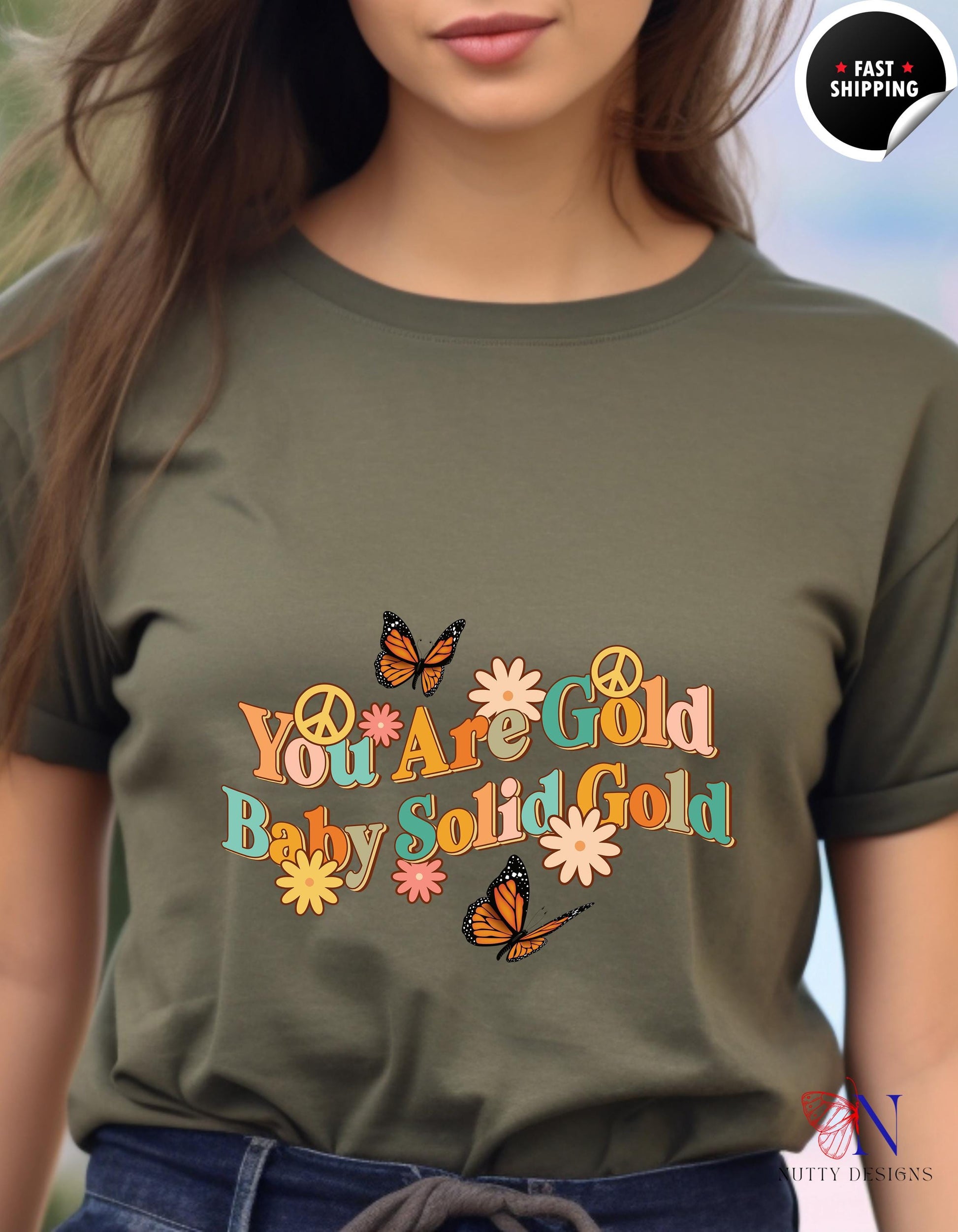 a woman wearing a t - shirt that says, you are gold, baby gold