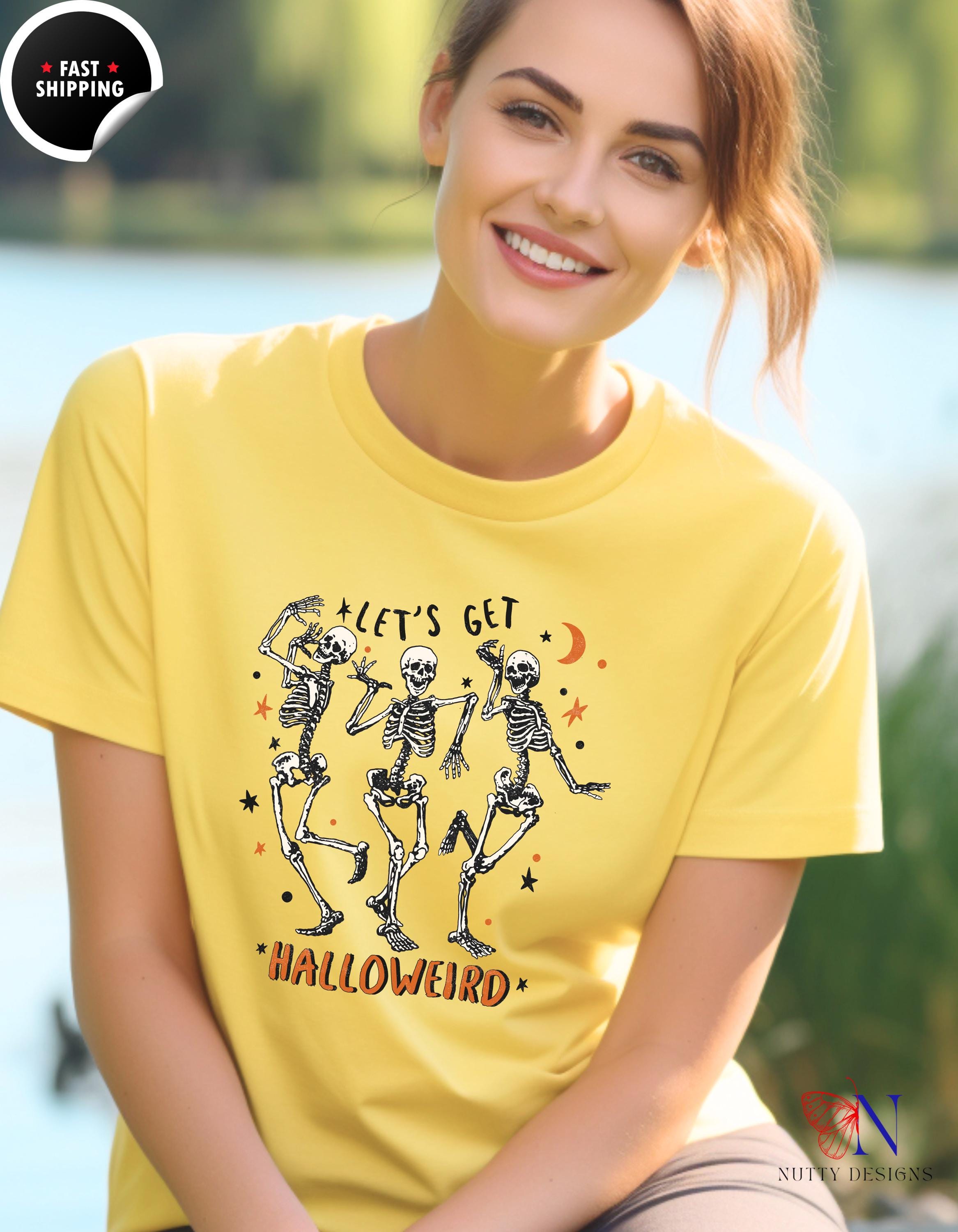 a woman wearing a yellow shirt with skeletons on it