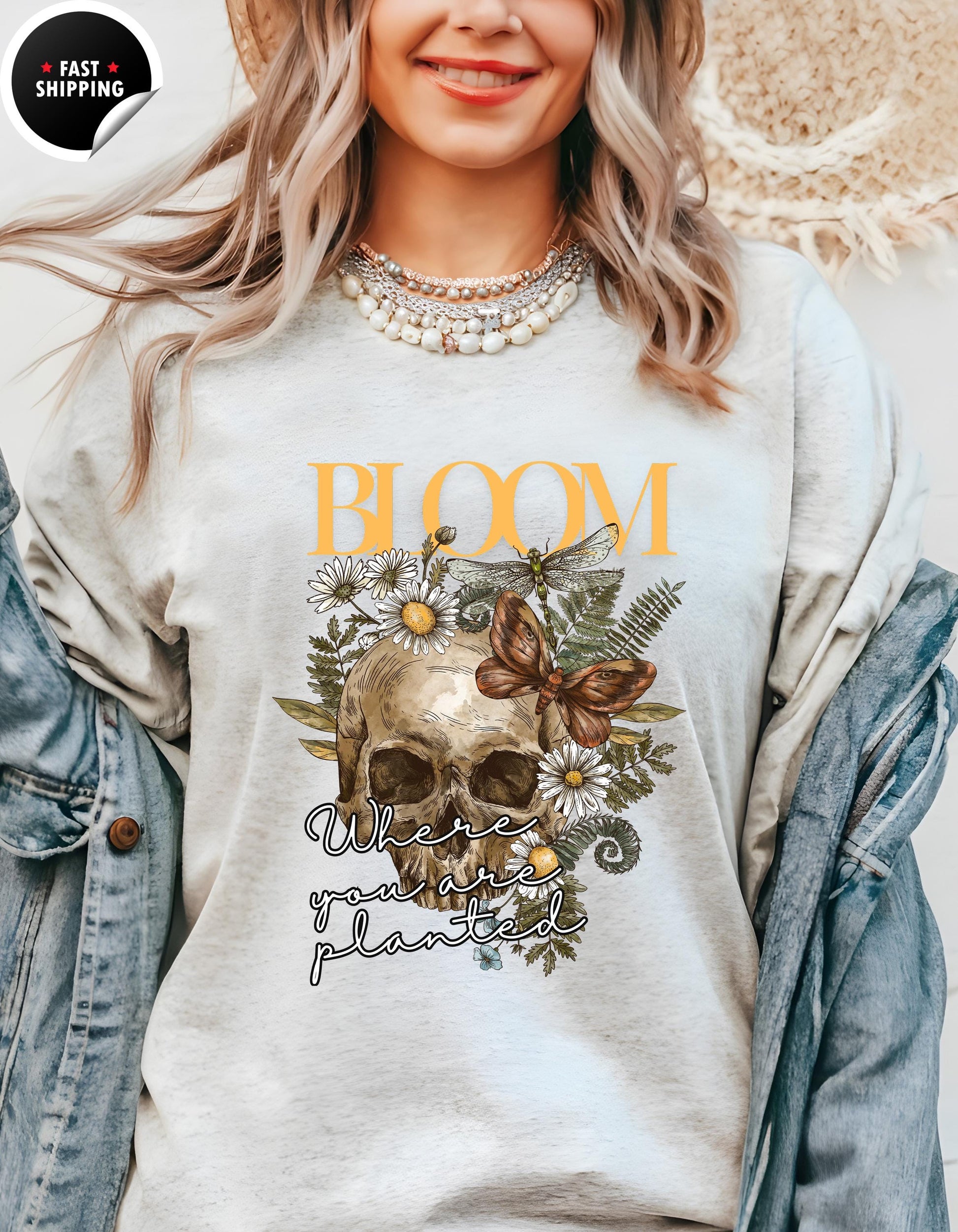 a woman wearing a t - shirt with a skull and flowers on it