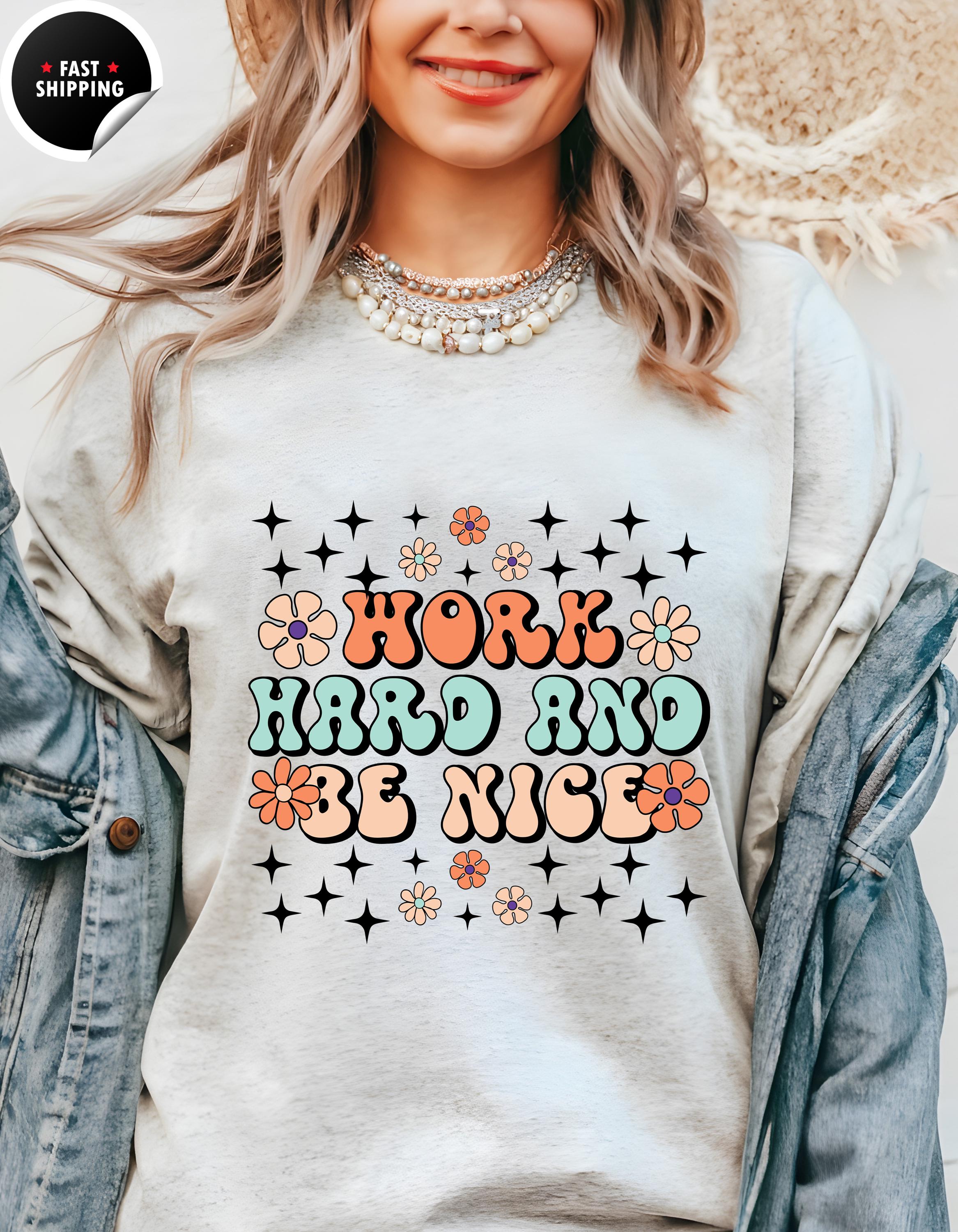 a woman wearing a sweatshirt that says work hard and be nice