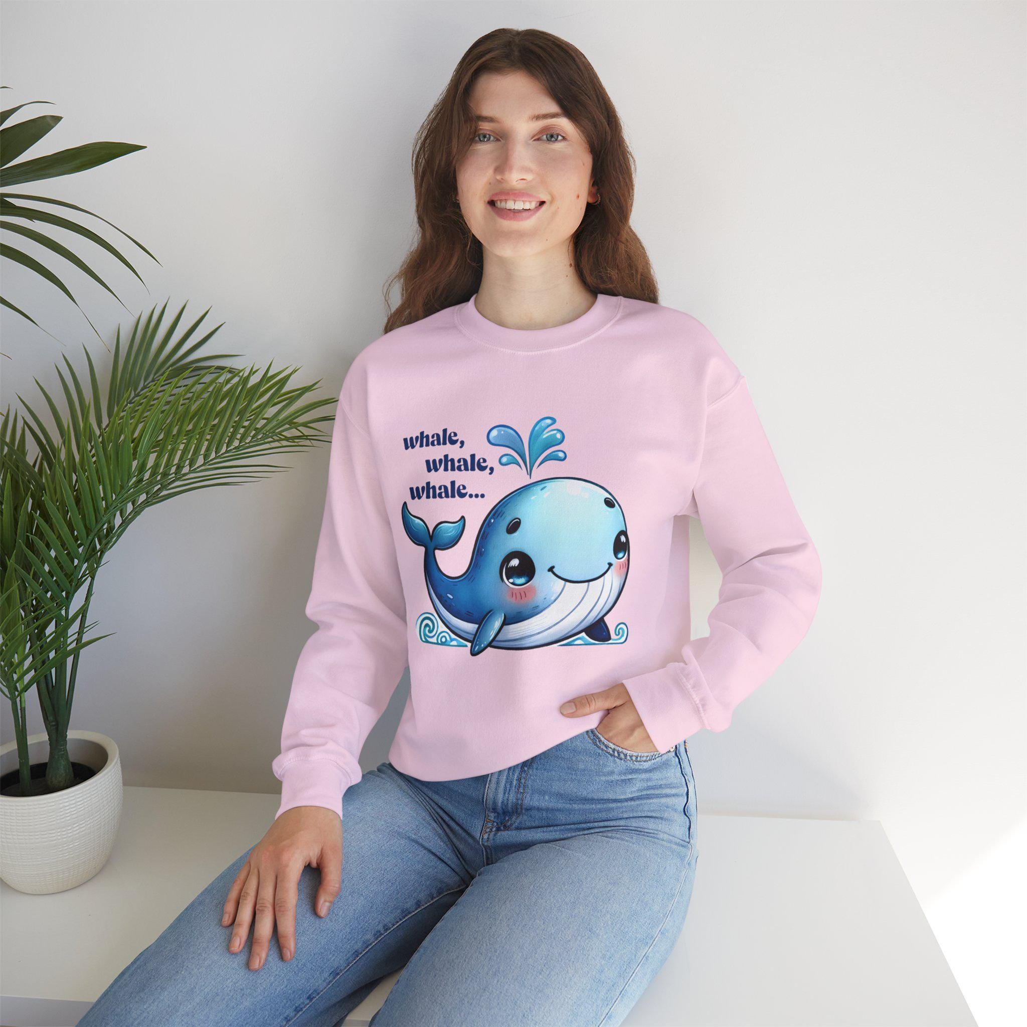 Cute pink sweatshirt featuring a happy cartoon whale design with text 'whale, whale, whale...' for animal lovers.