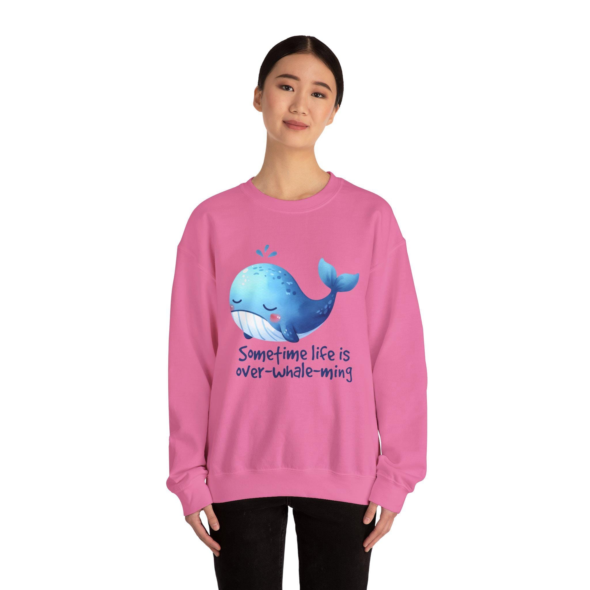 Pink sweatshirt printed with 'Sometime life is over-whale-ming' and a cute whale graphic.