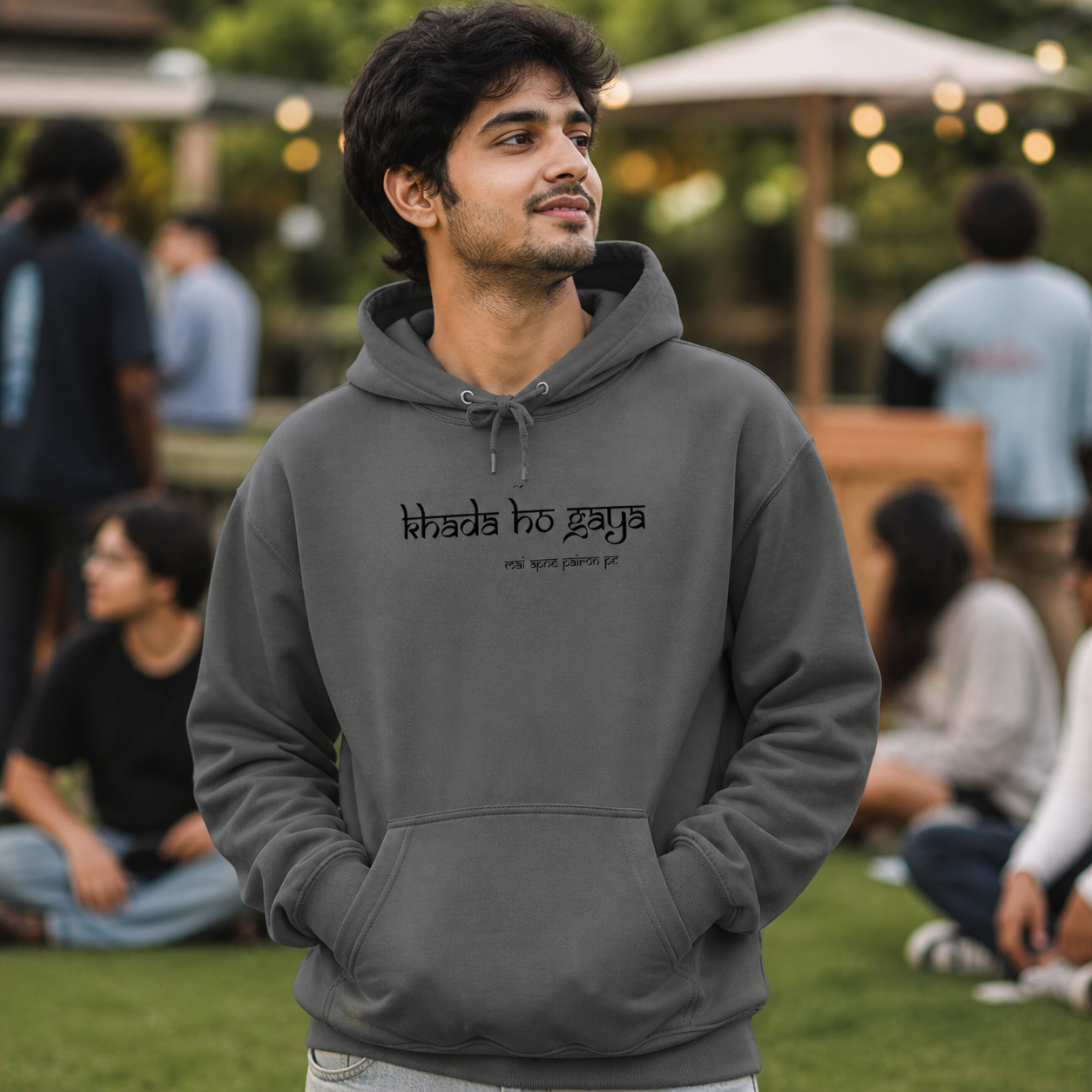 Young Indian man wearing charcoal Lo Khada Ho Gaya graphic hoodie outdoors