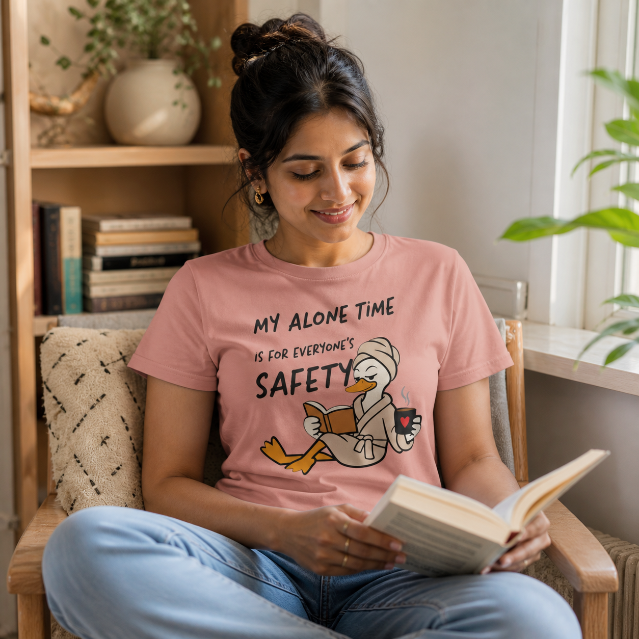 Young mom wearing My Alone Time Is for Everyone's Safety duck graphic T-shirt while reading