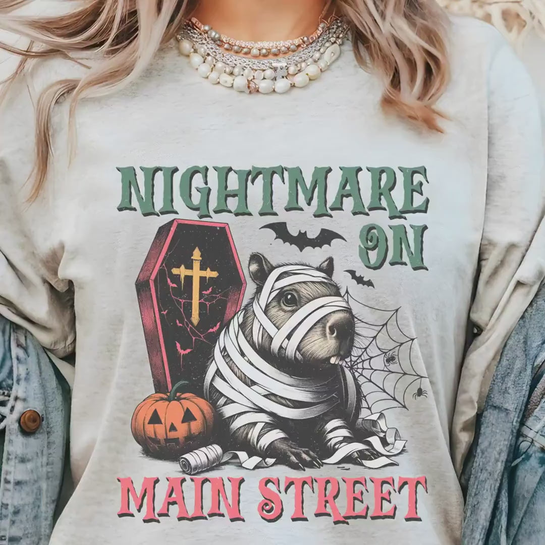 Load video: Nightmare-on-Main-Street Capybara Mummy Halloween T-shirt, Cute Halloween Tee, Spooky Gifts for Animal Lovers, Seasonal Fall Autumn Tee