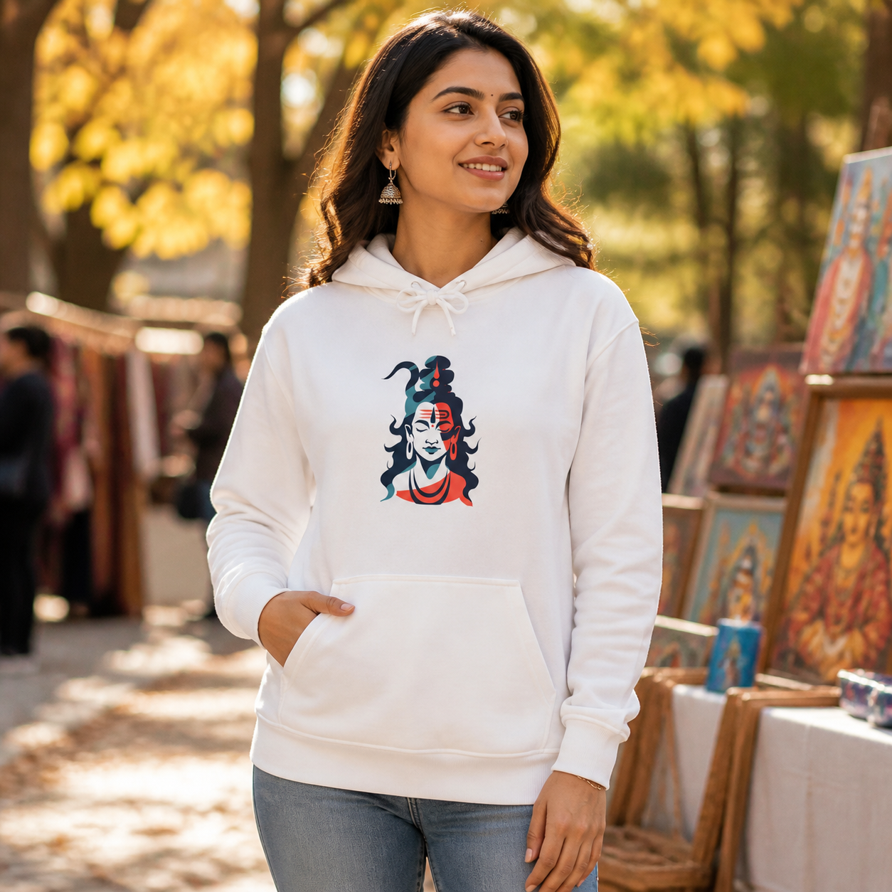 South Asian woman wearing tricolor Shiva graphic hoodie at an outdoor arts market