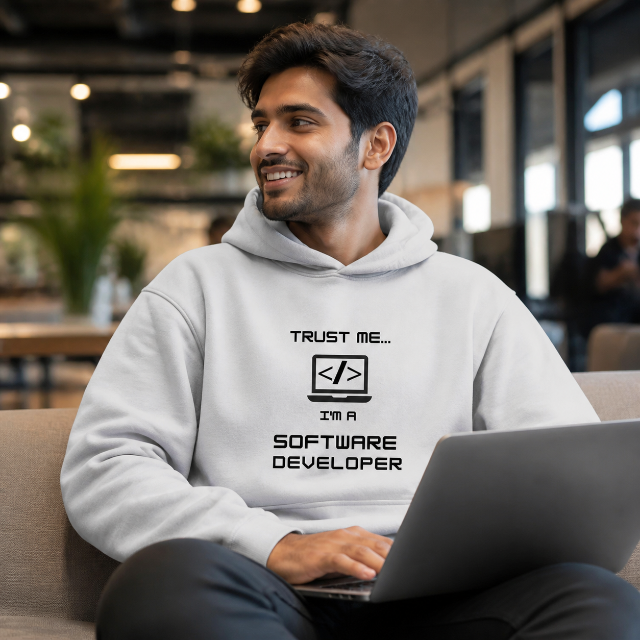 Young software developer wearing Trust Me software developer hoodie