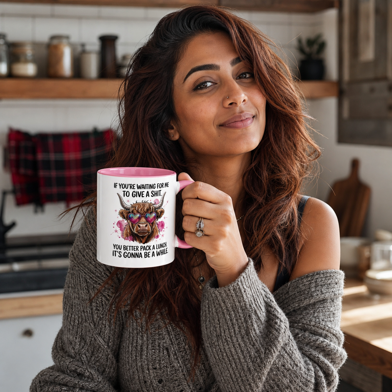 Young woman holding pink-accent sarcastic Highland cow mug in a modern kitchen